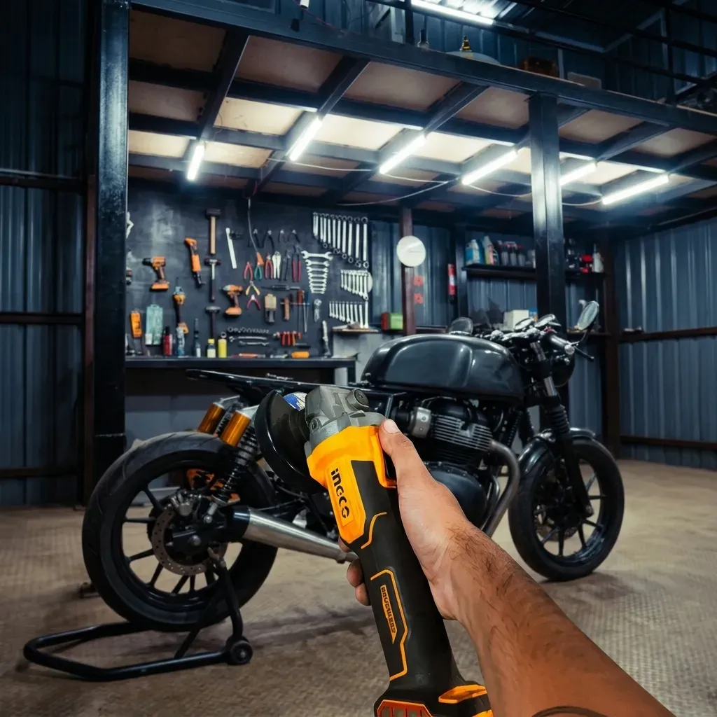 Mechanic holding an angle grinder next to a motorcycle frame in a workshop