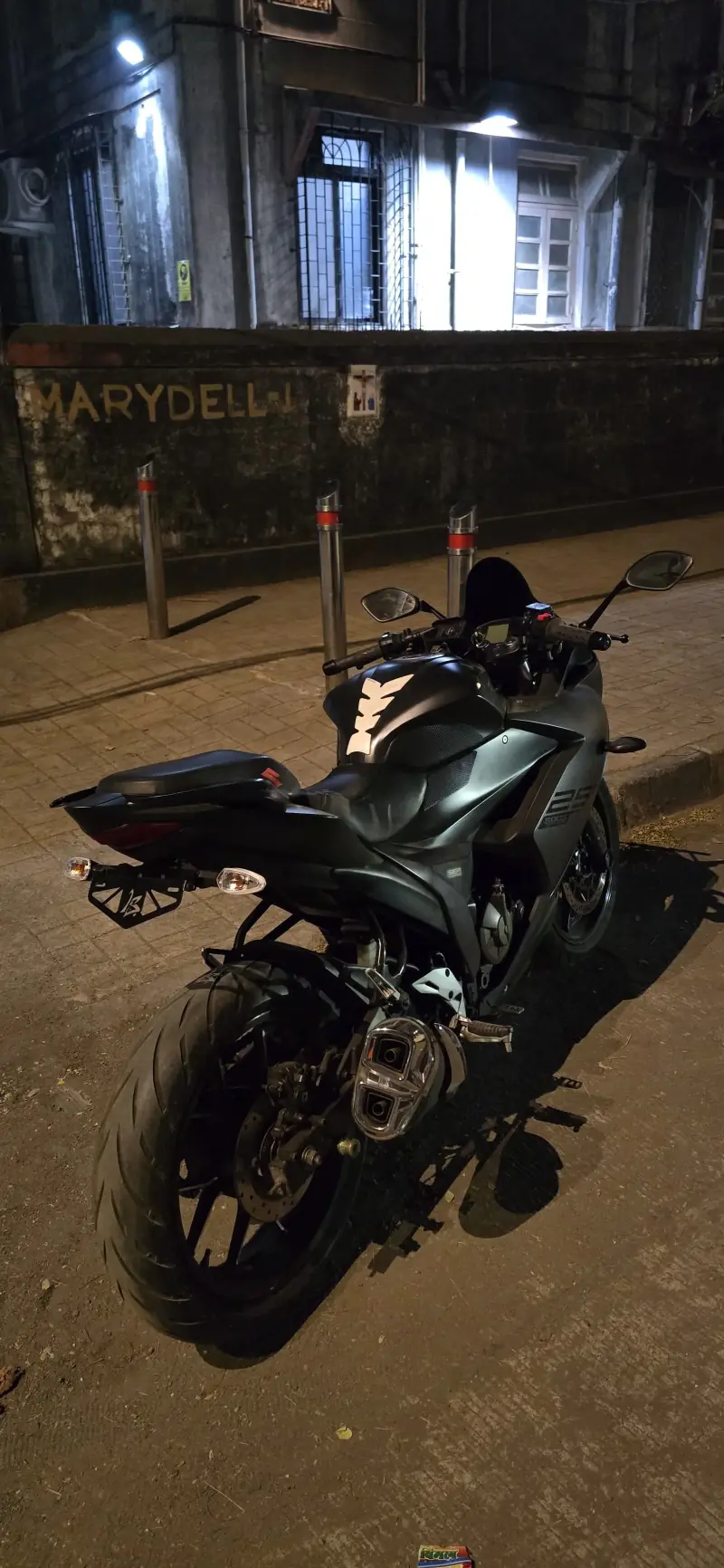 Black sport motorcycle fitted with an LS Customs tail tidy and compact number plate bracket at night