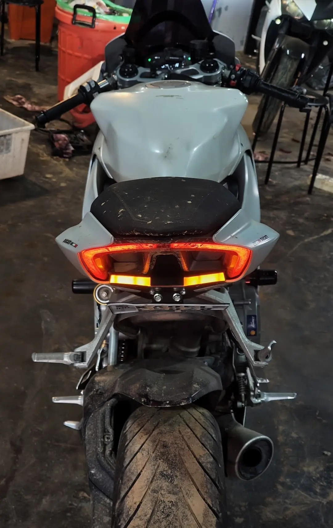 Rear view of a grey sport motorcycle in the workshop with both Split LED indicators illuminated